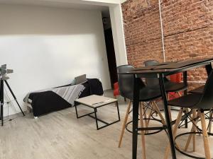 a room with a table and chairs and a brick wall at Pucara Apart - Habitaciones con baño privado in Corrientes