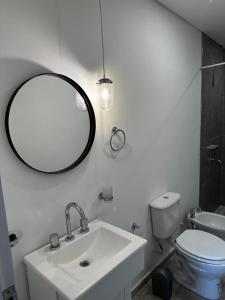 a bathroom with a sink and a mirror and a toilet at Pucara Apart - Habitaciones con baño privado in Corrientes