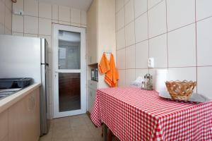 a kitchen with a table with a red and white checkered table cloth at My Cozy Place in Bucharest