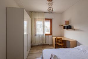a bedroom with a bed and a desk and a window at Kris- Mestre Bright Apartment with Parking! in Mestre