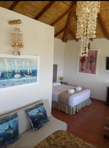 1 dormitorio con 2 camas y 1 sofá en una habitación en Aquamare Bungalows, en Cruz de Pizarro