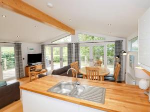 a kitchen and living room with a sink and a table at 9 Valley View in Looe