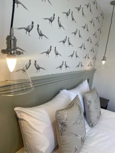 a bed with a bunch of birds on the wall at The Horseshoe & Castle in Rochester