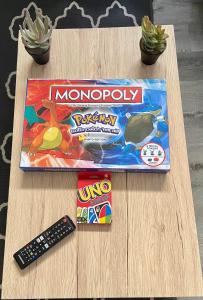 une boîte de monopole et une télécommande sur une table dans l'établissement London Downtown Home, à London