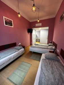two beds in a room with red walls at Klauzal19 Rooms in Budapest +25 photos