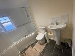 a bathroom with a sink and a toilet and a shower at Lovely 3-Bedroom Townhouse in Harold Wood