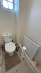 a bathroom with a toilet and a radiator at Lovely 3-Bedroom Townhouse in Harold Wood