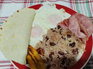 a plate of food with rice and meat and eggs at Gran Hotel Desamparados in Desamparados