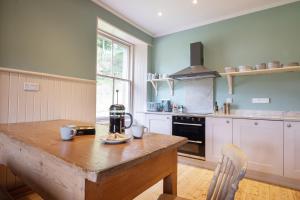 a kitchen with a wooden table and a counter top at Lassintullich House East Wing in Kinloch Rannoch