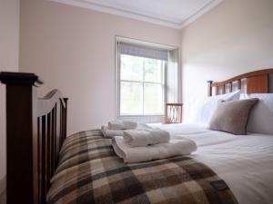 a bedroom with a large bed with towels on it at Lassintullich House East Wing in Kinloch Rannoch