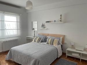ein weißes Schlafzimmer mit einem Bett und einem Fenster in der Unterkunft TikaHome in Marín