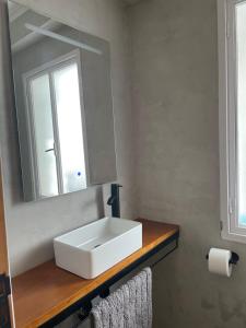 ein Badezimmer mit einem weißen Waschbecken und einem Spiegel in der Unterkunft TikaHome in Marín