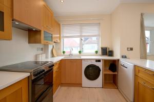 a kitchen with a washing machine and a sink at Stylish 4Bed 2 Bath, NW London Large Apartment in London