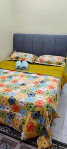 two beds with colorful sheets and pillows at Homestay Kasih KandAdinda in Kampung Gurun