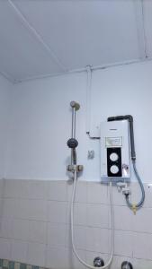 a shower in a bathroom with a machine on the wall at Seafront Corus Resort Port Dickson in Port Dickson
