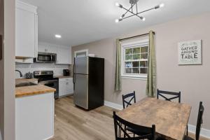uma cozinha com uma mesa e um frigorífico em Dog-Friendly, Renovated 3 Bedroom Home! em Jacksonville