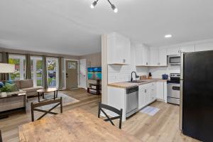 uma cozinha e sala de estar com uma mesa e um frigorífico em Dog-Friendly, Renovated 3 Bedroom Home! em Jacksonville