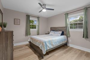 um quarto com uma cama e uma ventoinha de tecto em Dog-Friendly, Renovated 3 Bedroom Home! em Jacksonville