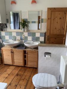 een badkamer met 2 wastafels en een toilet bij Wohnen in Schlossnähe in Schwerin