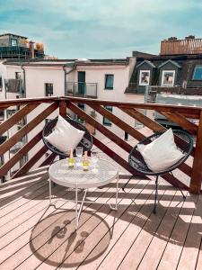 a patio with two chairs and a table on a deck at Rooftop Feeling erleben Sie Leipzig von oben in Leipzig