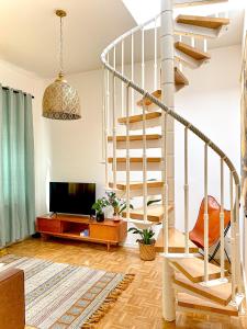 a living room with a staircase and a tv at Rooftop Feeling erleben Sie Leipzig von oben in Leipzig