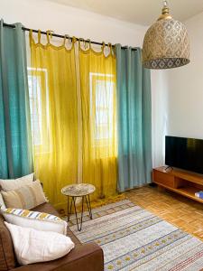 a living room with blue and yellow curtains and a couch at Rooftop Feeling erleben Sie Leipzig von oben in Leipzig