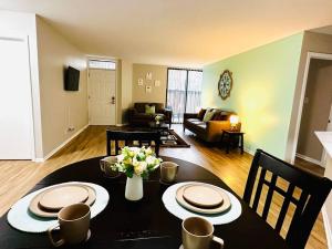 una sala de estar con una mesa con platos y flores. en Charming Retreat in Oak Park, IL Modern Comforts, en Oak Park