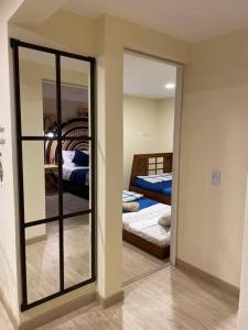 einen Spiegel in einem Zimmer mit 2 Betten und einem Schlafzimmer in der Unterkunft Magnifico apartamento in Bogotá