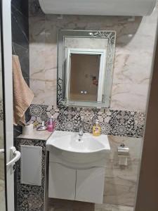 Луксозен апартамент с гледка към парк и център في Yambol: حمام مع حوض أبيض ومرآة