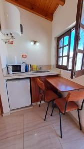 eine Küche mit einem Holztisch und Stühlen im Zimmer in der Unterkunft Rincón con Encanto in Salta