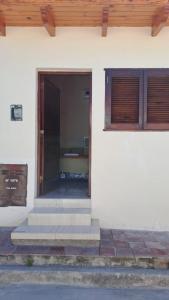 uma porta da frente de uma casa branca com escadas em Rincón con Encanto em Salta