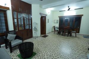 uma sala de estar com mesa e cadeiras em Ritu Homestay em Trivandrum