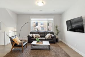 uma sala de estar com um sofá de couro e uma mesa em Luxury Hillhurst Home Central Location 3 Br em Calgary