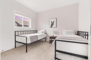 una camera con due letti e una finestra di Luxury Hillhurst Home Central Location 3 Br a Calgary