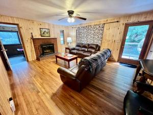 a living room with a leather couch and a fireplace at Creekside Haven in Gatlinburg