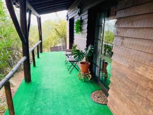 una veranda di una casa con pavimento verde di Poolside Wooden House a Moçarria