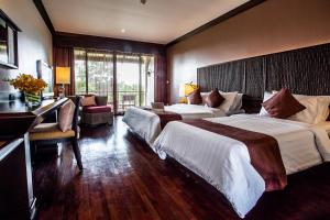 a hotel room with two beds and a desk at Maneechan Resort - SHA Extra Plus in Chanthaburi