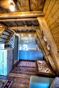- une cuisine dans une cabane en rondins avec des armoires bleues dans l'établissement Cabanuta Sofia, à Slon