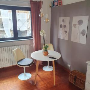 uma mesa e duas cadeiras e uma mesa com flores em Gaia Suites em Turim