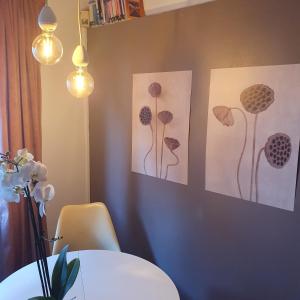 Gaia Suites في تورينو: غرفة طعام مع صورتين لزهور على الحائط