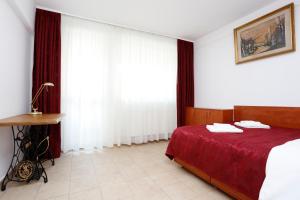 ein Schlafzimmer mit einem Bett mit einer roten Decke in der Unterkunft My Cozy Place in Bukarest