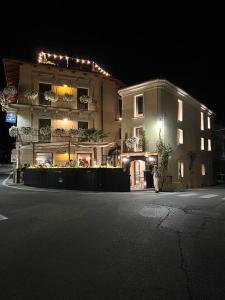 un edificio con una persona de pie delante de él por la noche en La Piazzetta degli Artisti - Boutique B&B en Bossolasco