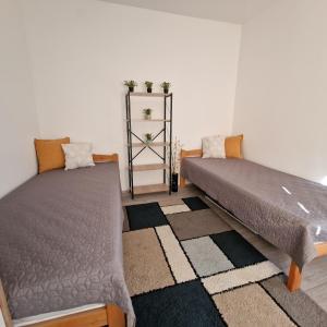 a bedroom with two beds and a rug at Apartman "Lola" in Pirot