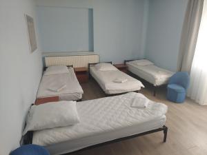 a hospital room with three beds and a chair at Willa Marina in Łódź