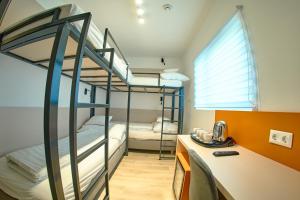 ヴェスプレームにあるIce Premium Apartmentsの二段ベッド2台、デスクが備わる客室です。