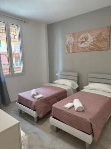 um quarto com 2 camas e toalhas em CASA ANGELA Vista mare em Ventimiglia