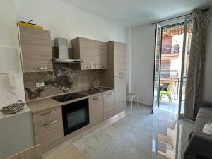 a kitchen with wooden cabinets and a glass door leading to a patio at CASA ANGELA Vista mare in Ventimiglia