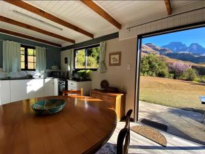 cocina con mesa de madera y ventana grande en Highbourne Cottages, en Winterton