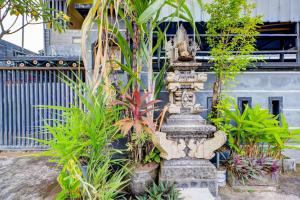 OYO Life 92841 Kos 88 في Negara: تمثال حجري في حديقة بها نباتات