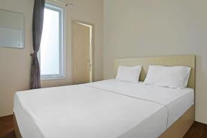 ein weißes Bett in einem Zimmer mit Fenster in der Unterkunft OYO Life 92720 Mekarwangi Guest House in Bandung